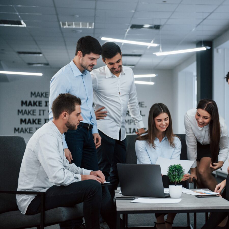 Into success. Group of young freelancers in the office have conversation and smiling Into success. Group of young freelancers in the office have conversation and smiling.